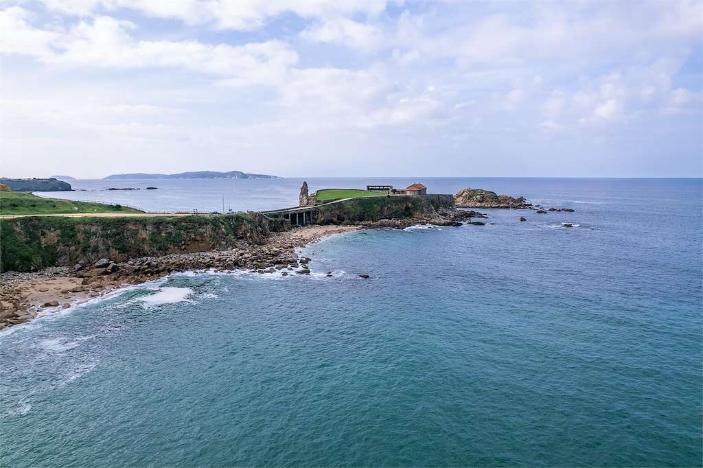 Vistas costeras desde la ermita, con olas rompiendo en las rocas